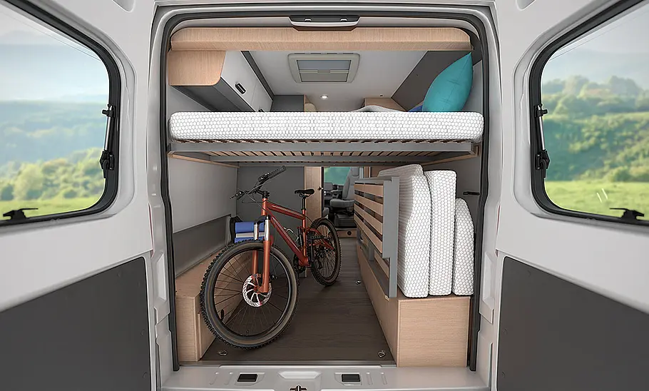 Das Bild zeigt die Etagenbetten im Heck des Sunliving V 60 SP Family (2025) durch die geöffneten Hecktüren fotografiert. Das untere Bett ist zur Seite geklappt, ein Fahrrad steht in der Heckgarage.