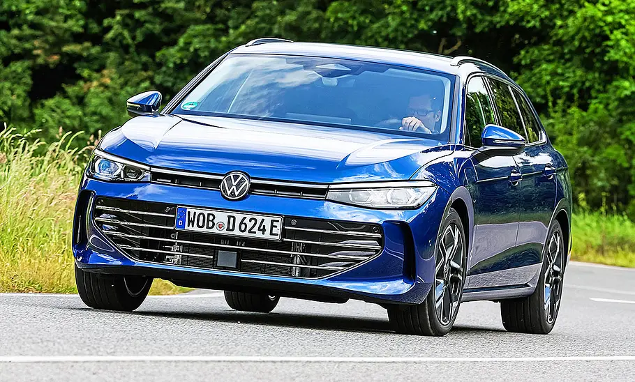 Blick von schräg vorne auf den fahrenden Kombi VW Passat 1.5 eHybrid.