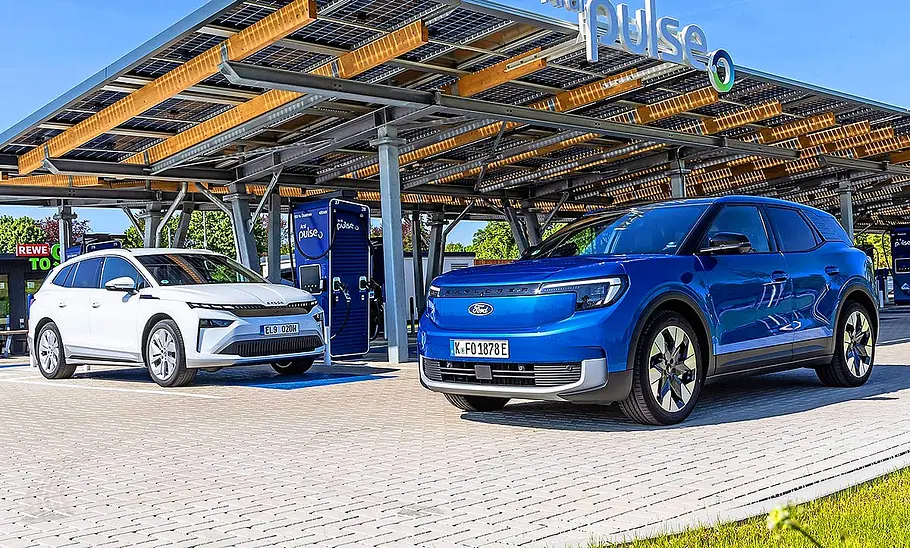 Gruppenbild mit Blick von schräg vorne auf die beiden E-SUV Skoda Enyaq und Ford Explorer.