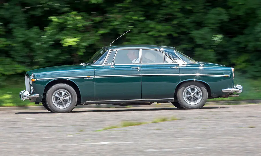 Der Rover P5B Coupé fährt auf einer Straße, fotografiert von der Seite.