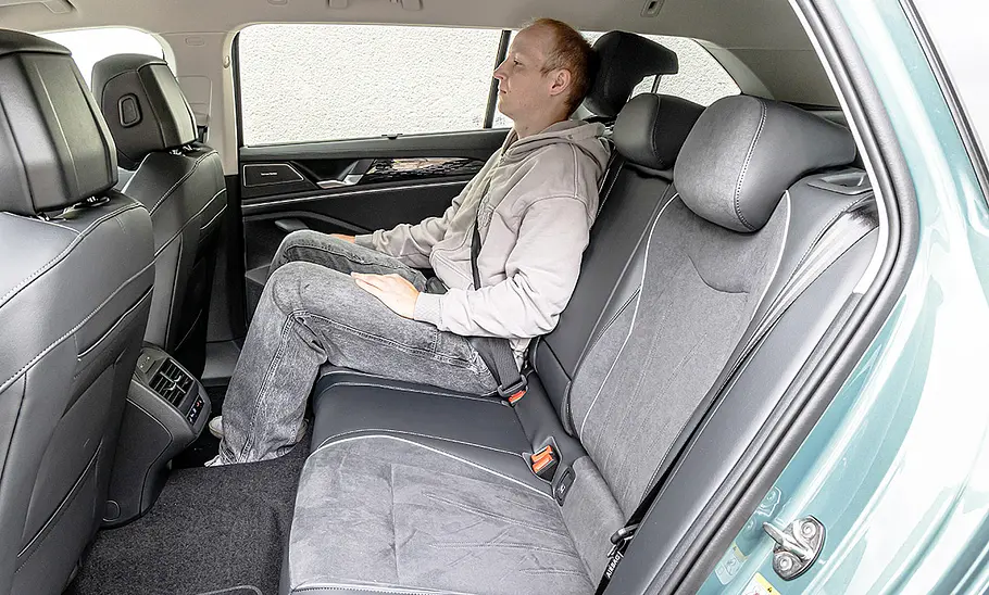 VW Passat Eine Person sitzt auf dem rechten Rücksitz des VW Passat. Durch die hintere, linke Tür fotografiert.