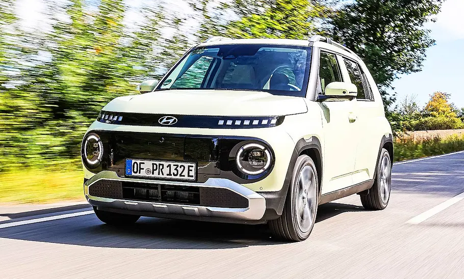 Blick von schräg vorne auf den fahrenden Hyundai Inster.