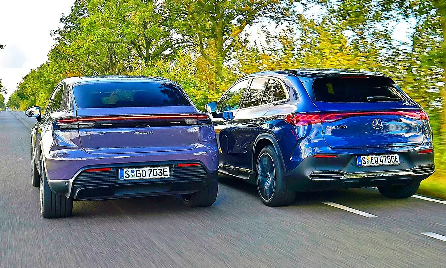 Porsche Macan Electric/Mercedes EQE SUV Blick von hinten auf die fahrenden Porsche Macan Electric und Mercedes EQE SUV.