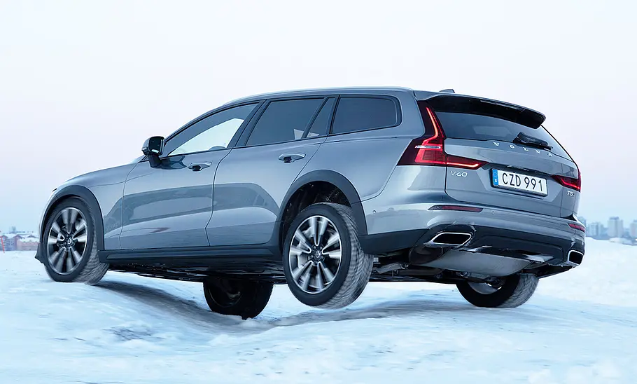 Der Volvo V60 Cross Country (2018) fährt im Schnee über eine tiefe Querfuge, das linke Hinterrad hat keinen Bodenkontakt.