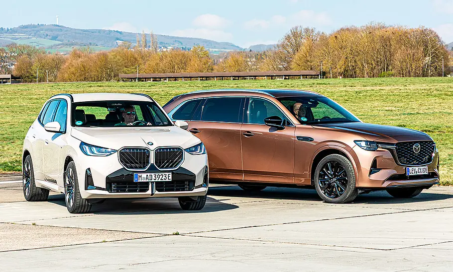 Blick von schräg vorne auf die beiden SUV BMW X3 und Mazda CX-80.