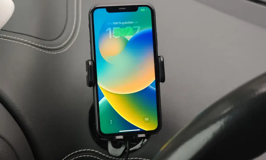 Handyhalterung fürs Auto mit Ladefunktion im Test Der Joyroom Wireless Car Charger Holder am Lüftungsgitter mit Handy im Hochformat.