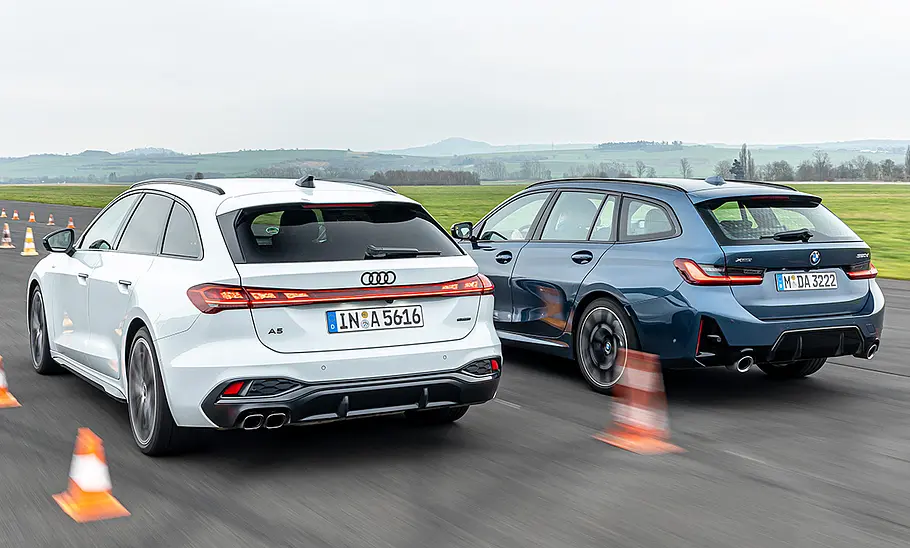 Audi A5 Avant und BMW 3er Touring fahren nebeneinander auf einer Flugzeuglandebahn, von hinten links fotografiert.
