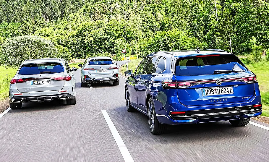 Blick von hinten auf die drei fahrenden Kombis Mercedes E 300 e T-Modell, BMW 530e Touring und VW Passat 1.5 eHybrid.