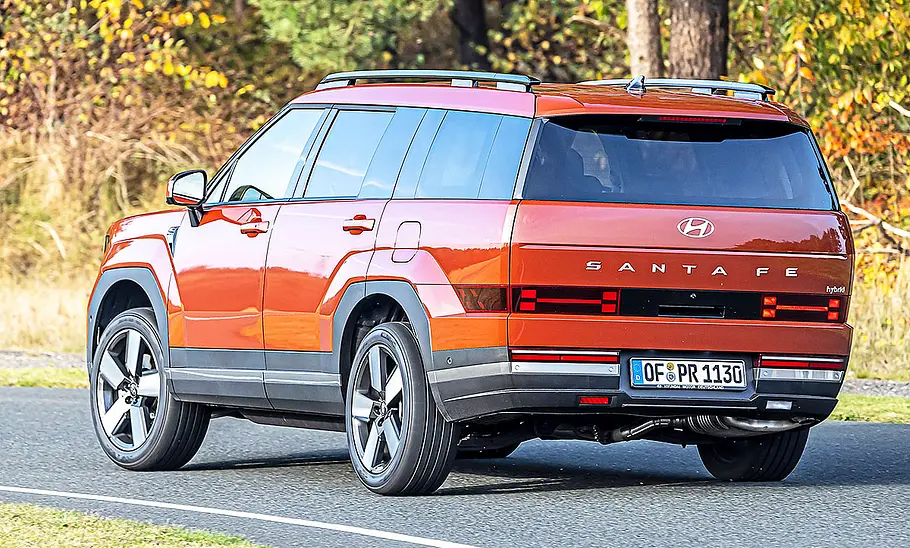 Blick von schräg hinten auf den fahrenden Hyundai Santa Fe.