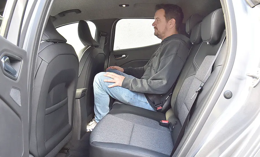Eine Person sitzt auf der Rücksitzbank des Mitsubishi Colt Hybrid.