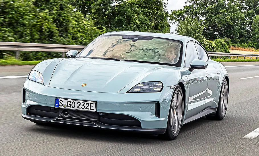 Blick von schräg vorne auf den fahrenden Porsche Taycan.