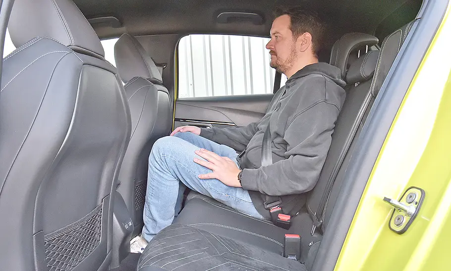 Eine Person sitzt auf der Rücksitzbank des Peugeot 208 Hybrid.