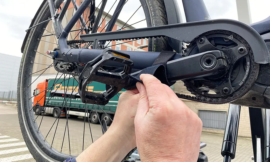 Test-Redakteur beim Fixieren eines Pedals mit Klettverschluss am Hinterbau.