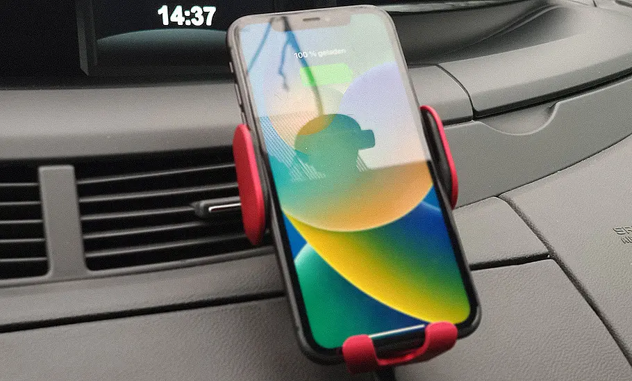 Handyhalterung fürs Auto mit Ladefunktion im Test Der Gumaxx Smart Sensor S11 am Lüftungsgitter mit Handy im Hochformat.