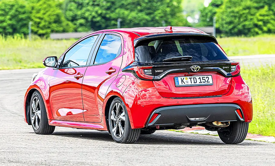Blick von schräg hinten auf den fahrenden Toyota Yaris.