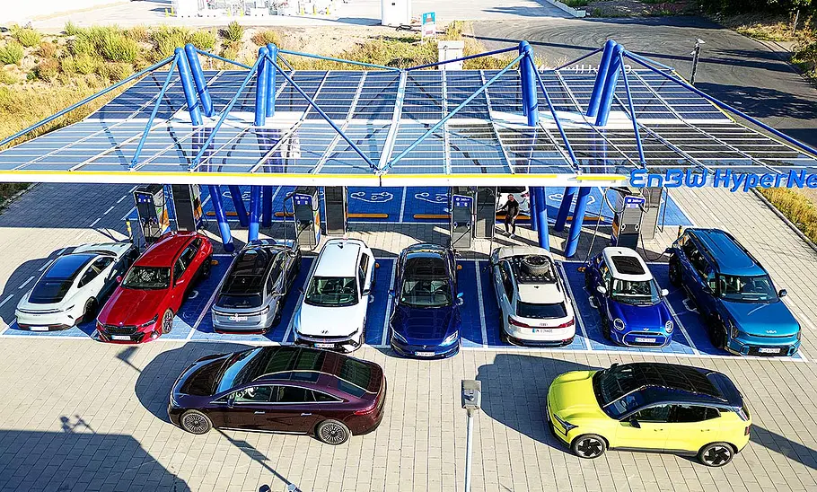 Alle Kandidaten zum Elektroauto des Jahres 2024 bei einer Ladestation.