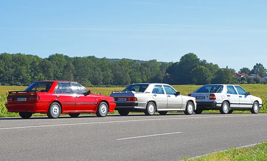 Nissan Bluebird/Mercedes 190 E 2.5-16/Saab 9000 2.3i 16V Nissan Bluebird, Mercedes 190 E 2.5-16 und Saab 9000 2.3i 16V stehend von hinten.