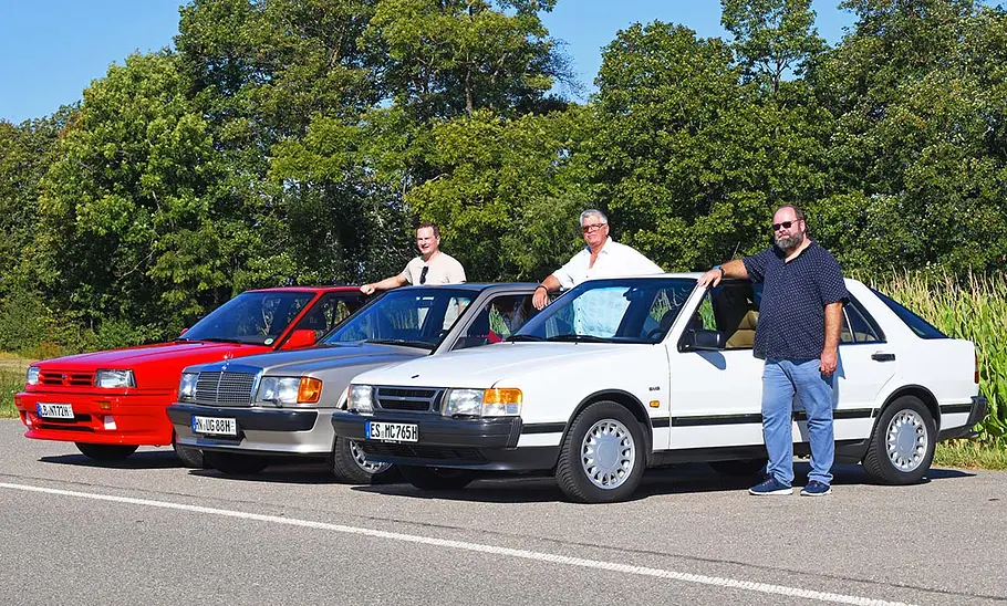 Nissan Bluebird/Mercedes 190 E 2.5-16/Saab 9000 2.3i 16V Nissan Bluebird, Mercedes 190 E 2.5-16 und Saab 9000 2.3i 16V stehend von schräg vorne.
