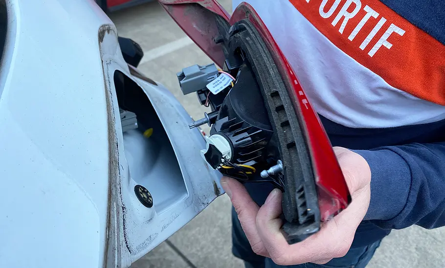 Tester beim Demontieren der linken Heckleuchte eines Ford Fiesta.