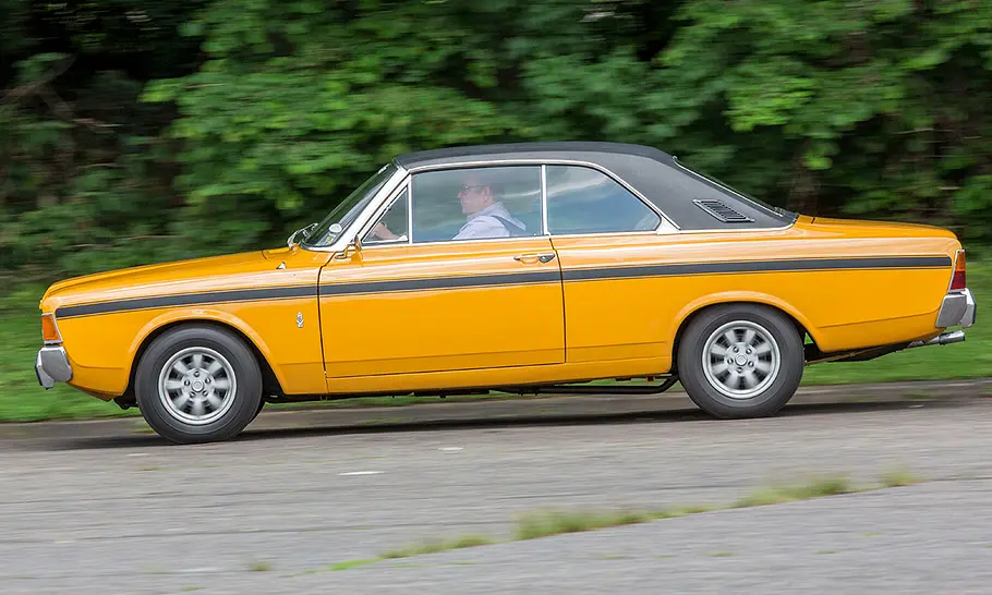 Der Ford 20M RS Coupé (P7b) fährt auf einer Straße, fotografiert von der Seite.