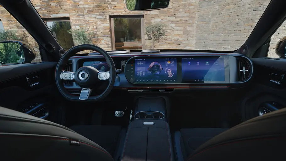 Der Blick von der Rückbank des Smart #5 Brabus zeigt ein schwarzes Autocockpit mit Lenkrad, breiter Displayfront und Mittelkonsole.