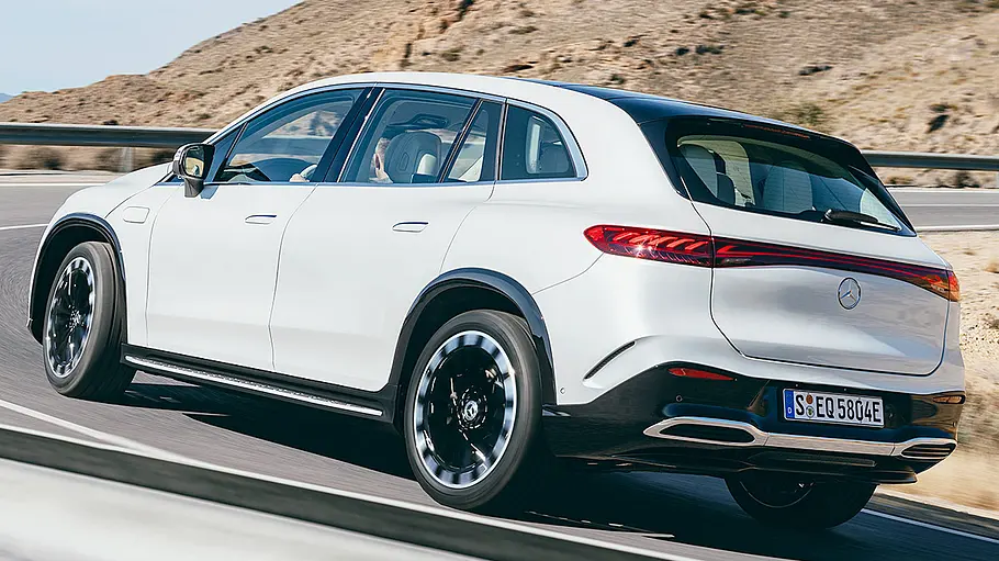 Mercedes EQS SUV Das Mercedes EQS SUV fährt durch eine Rechtskurve, von hinten links fotografiert.