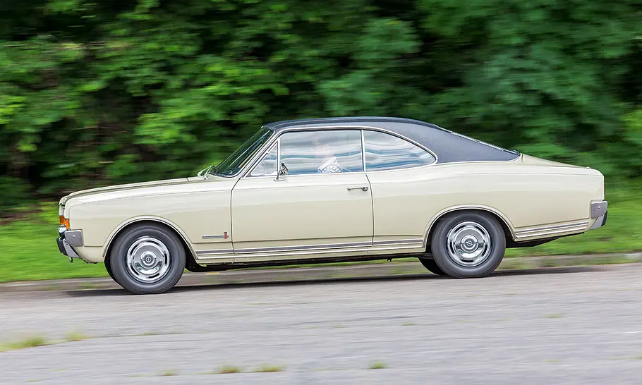 Der Opel Commodore A Coupé fährt auf einer Straße, fotografiert von der Seite.