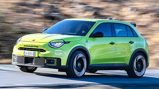 Der Abarth 600e (2024) fährt durch eine Kurve, von schräg vorne fotografiert. - Foto: Abarth Der Abarth 600e (2024) fährt durch eine Kurve, von schräg vorne fotografiert. - Foto: Abarth