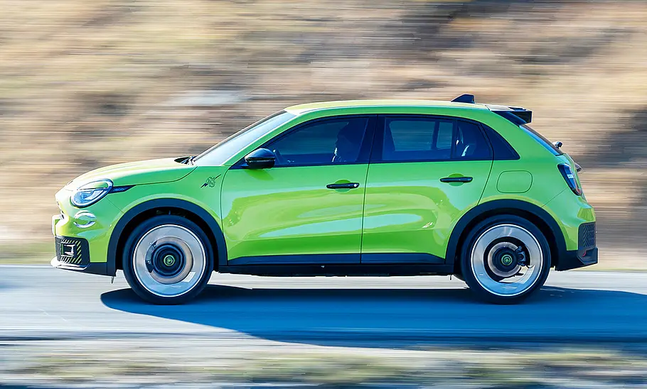 Der Abarth 600e (2024) fahrend von der Seite fotografiert.