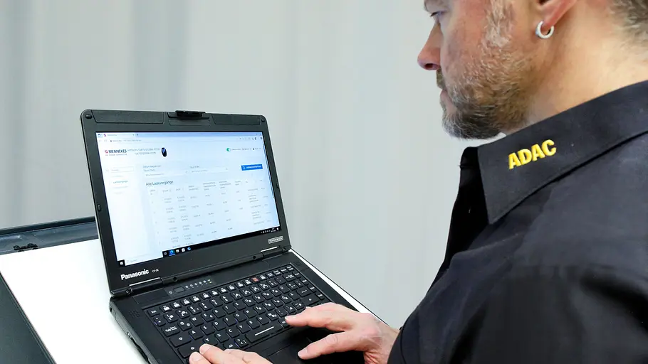 Ein ADAC-Mitarbeiter trägt Messwerte des ADAC-Wallboxen-Tests 2025 auf einem Laptop in eine Tabelle ein.