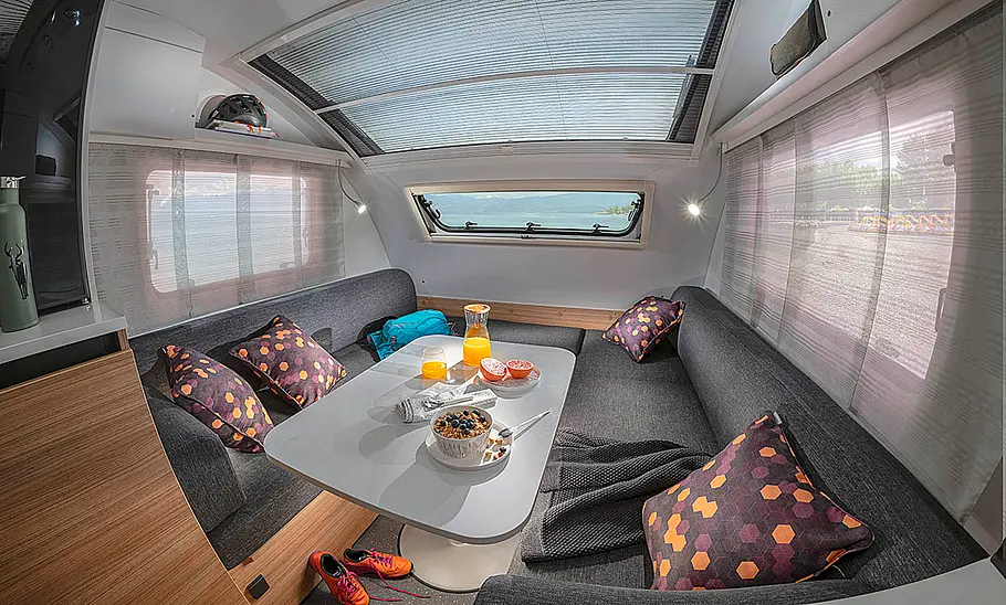 Der Wohnraum des Adria Action 361 LH (2024), fotografiert aus der rechten hinteren Ecke heraus.