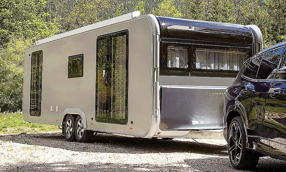 Der Adria Astella 904 HP (2026) von schräg vorne am Haken eines Zugfahrzeugs.