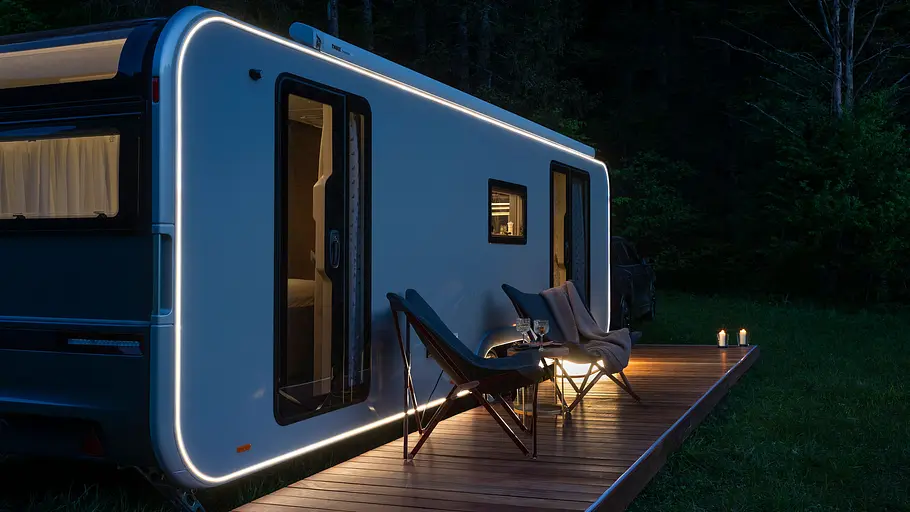 Vor dem Adria Astella 904 HP ist eine Veranda mit Faltstühlen aufgebaut.