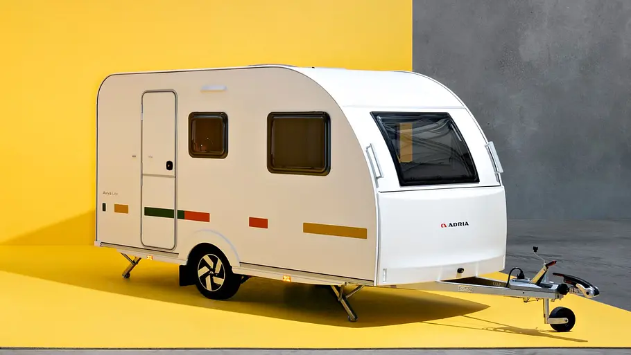 Adria Aviva Lite 360 DK Der Adria Aviva Lite statsich von schräg vorne links in einem gelb gestrichenen Studio.