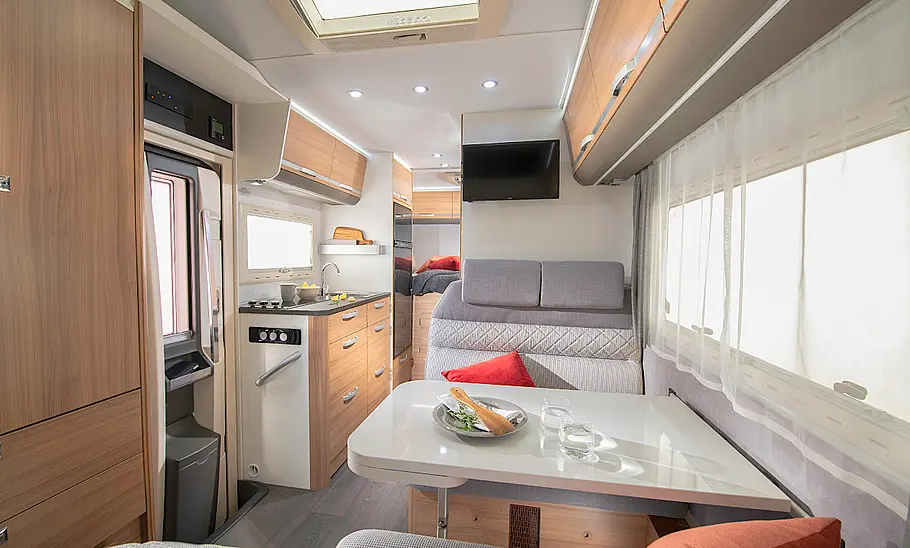 Das Bild zeigt die Sitzgruppe des Adria Coral XL 600 DP (2024) mit Blick in Richtung Heck.