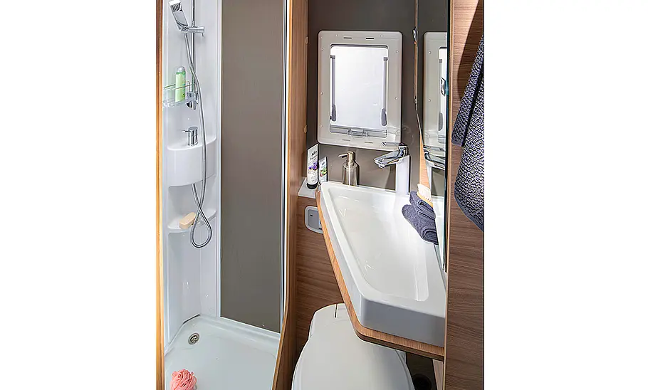 Das Bild zeigt das Badezimmer mit ausgeklapptem Waschbecken des Adria Coral XL 600 DP (2024).