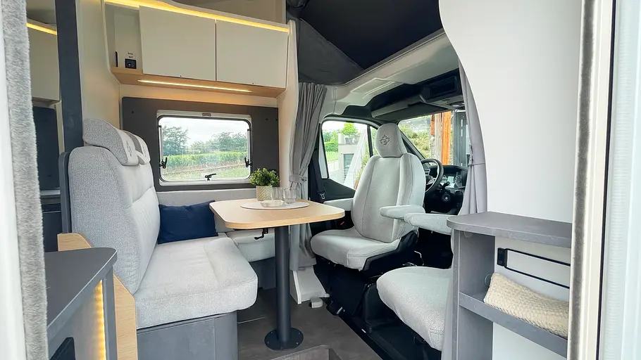 Blick durch die Aufbautüre des Ahorn Camp A 595 schräg auf die Sitzgruppe.