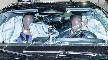 Der Innenraum des Audi A5 (2024) ist nach einem Euro NCAP-Crashtest durch die gesprungene Windschutzscheibe fotografiert. Zwei Dummies sitzen inmitten mehrere offener Airbags. - Foto: Euro NCAP Der Innenraum des Audi A5 (2024) ist nach einem Euro NCAP-Crashtest durch die gesprungene Windschutzscheibe fotografiert. Zwei Dummies sitzen inmitten mehrere offener Airbags. - Foto: Euro NCAP