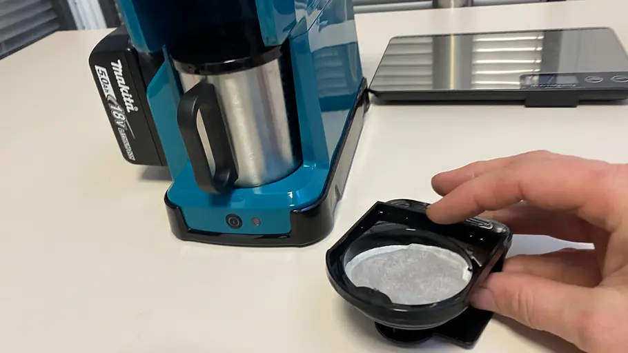 Akku-Kaffeemaschine von Makita mit Kaffeepad im Test, fotografiert von schräg oben.