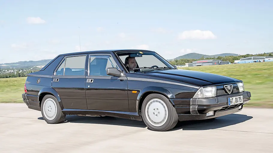 Alfa Romeo 75 3.0 QV fahrend von schräg vorne fotografiert. 