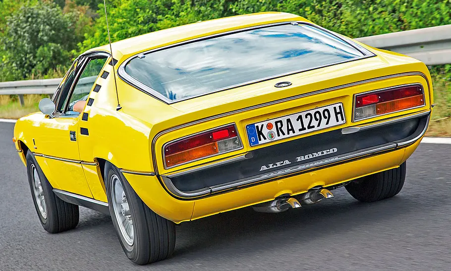 Der Alfa Romeo Montreal fahrend von schräg hinten