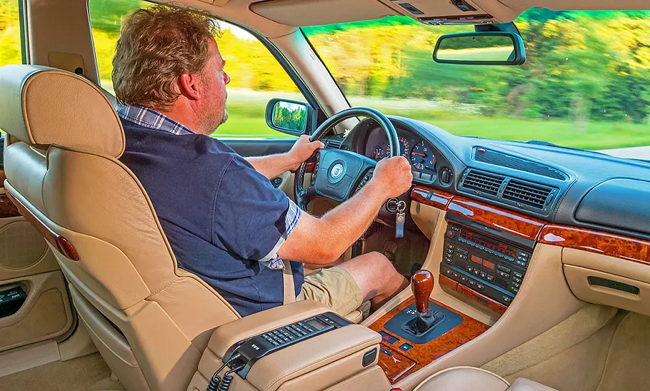 Eine Person am Steuer des Alpina B12 6.0.