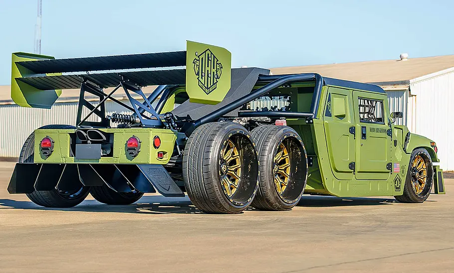 Ein getunter Humvee stehend von schräg hinten.