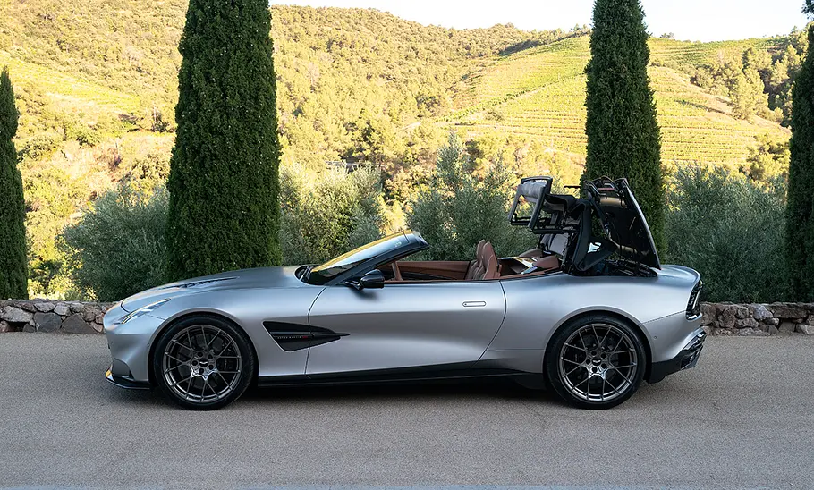 Der Aston Martin Vanquish Volante stehend mit einem sich gerade schließendem Verdeck.
