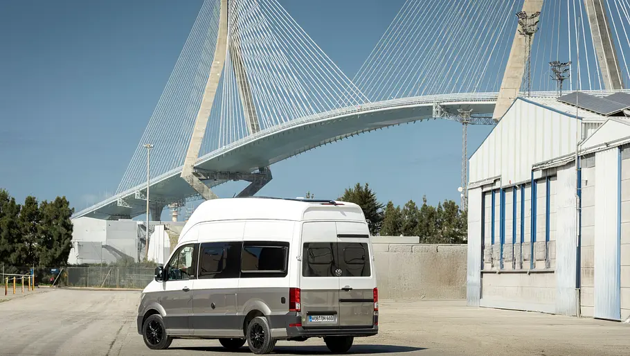 Der VW Grand California statisch von schräg hinten rechts vor der Puente De La Constitución De 1812 in Cádiz.