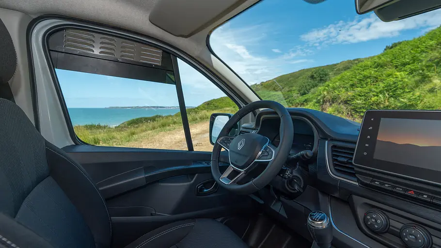 Blick vom Beifahrersitz auf das Cockpit des Antilope Van Flex 2 mit leicht geöffneter Seitenscheibe, in der ein Lüftungsgitter verkeilt ist.