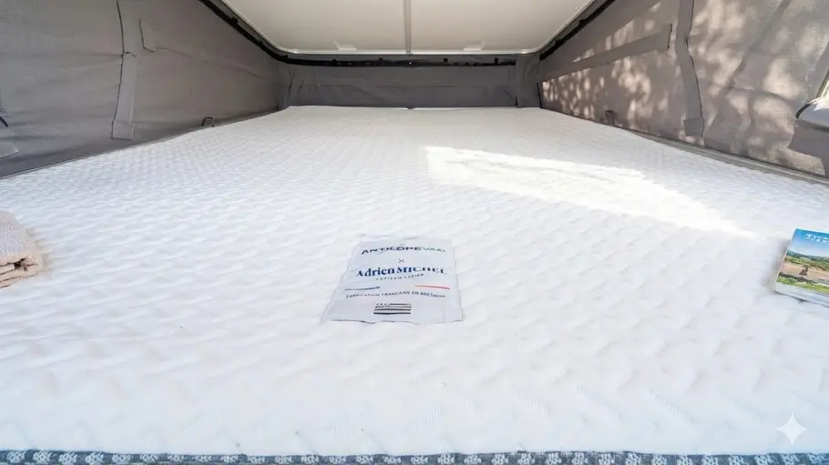 Die Innenaufnahme zeigt das Bett im Aufstelldach des Antilope Van Flex 5.
