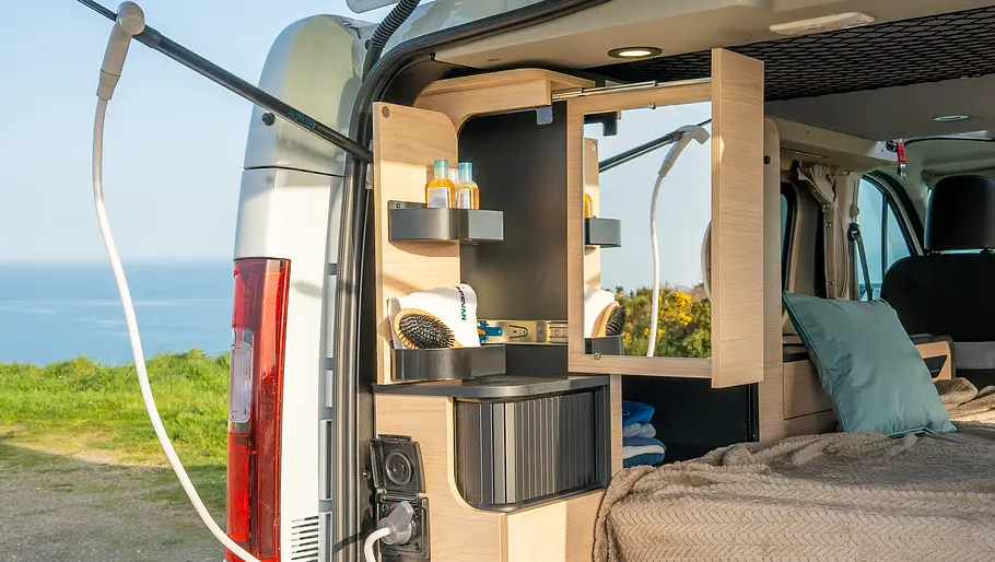 Das kompakte Bad am Heck des Antilope Van Flex 5 mit Außendusche, Spiegel und Schrank.