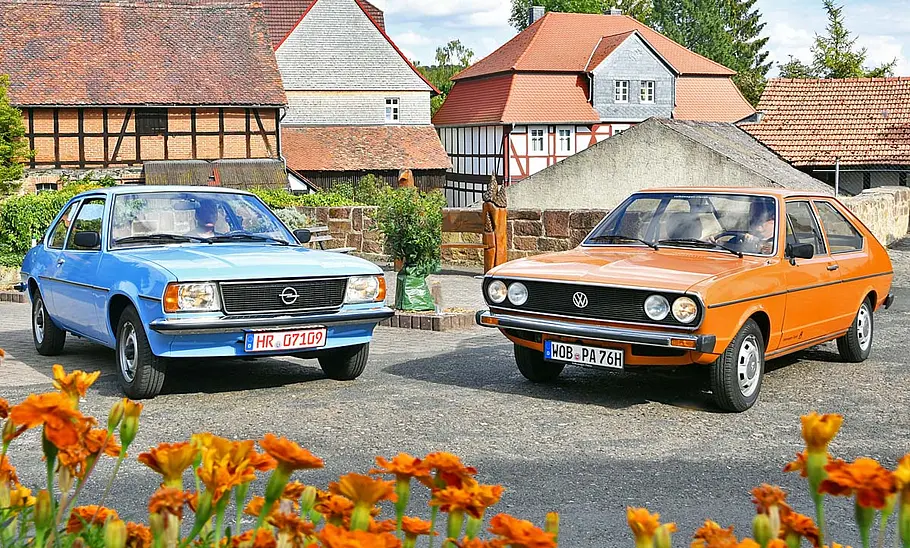 Opel Ascona B/VW Passat B1 stehend nebeneinander von vorne fotografiert.