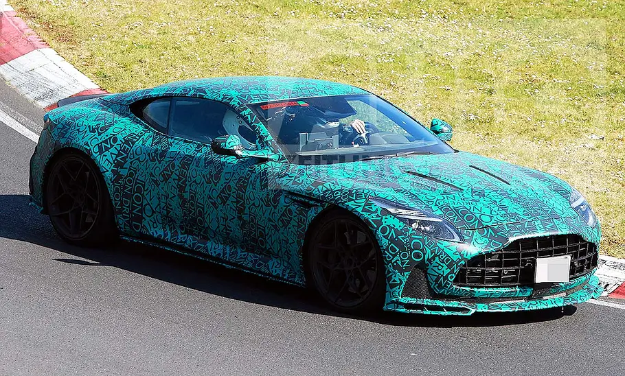 Aston Martin DB12 AMR Blick von schräg vorne auf den fahrenden Erlkönig des Aston Martin DB12 AMR.